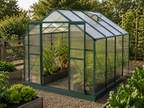 A greenhouse with a dark green frame and translucent panels, situated in a garden with plants, gravel, and wooden fencing in the background. Leading Landscapes Canterbury