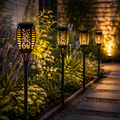 Orbit flame effect solar lights -Glowing solar garden lights along a pathway in a garden setting - Leading Landscapes Canterbury