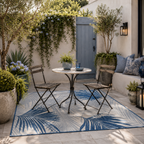 Outdoor patio with a small table and chairs on a blue patterned rug - Leading Landscapes Canterbury