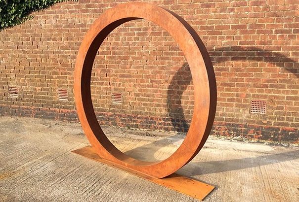 Corten steel ring art close-up showing weathered rust texture — Leading Landscapes Canterbury