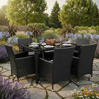 Black outdoor dining set with six chairs on a patio surrounded by greenery - Leading Landscapes Limited