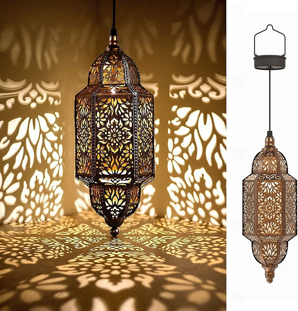 An ornate hanging lantern with intricate cutout detailing, shown lit and casting warm shadow patterns on a wall and floor. A smaller side view on the right shows the lantern from the back against a plain white background.