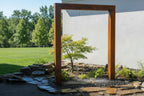 Thin Corten rain curtain water feature in a schist rock garden with planting - Leading Landscapes Limited