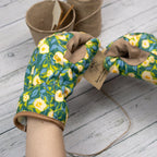 Pair of floral-patterned gardening gloves on a wooden surface with a small pot and twine in the background.